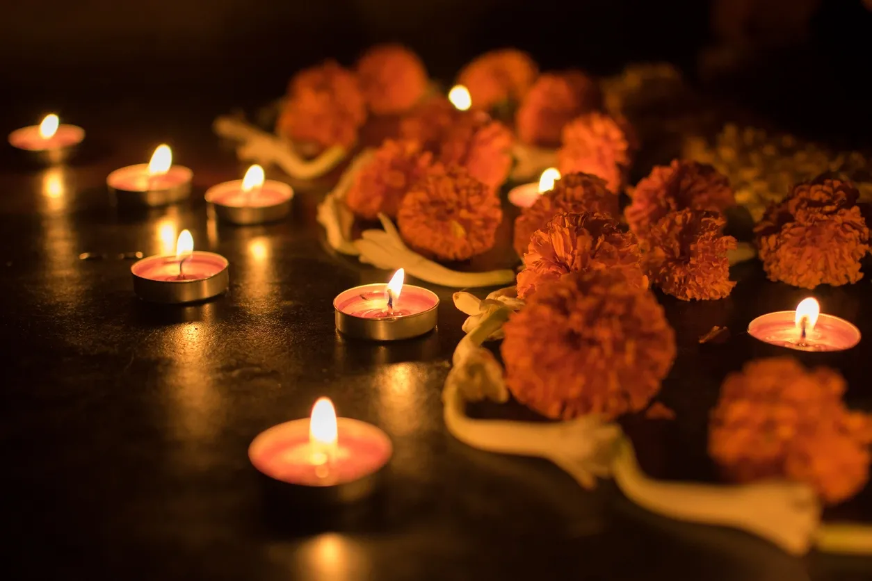 A table with some candles and flowers on it