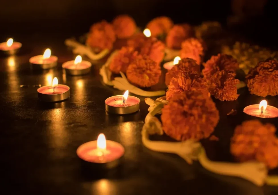 A table with some candles and flowers on it